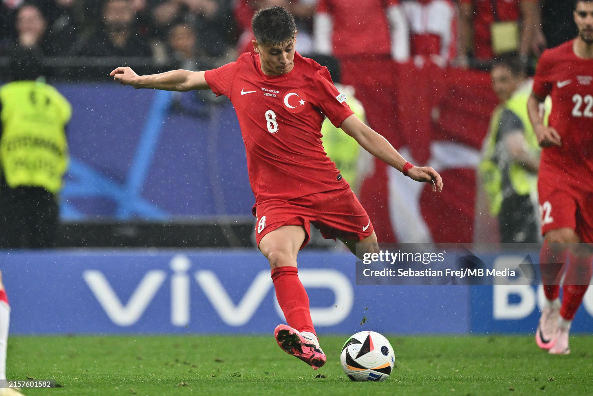 Turkey and Georgia players in action during Euro 2024 match at Westfalenstadion, with fans cheering in the background.