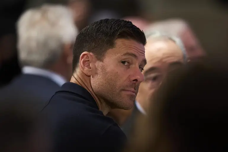 Real Madrid squad training under a watchful coach on a tense day
