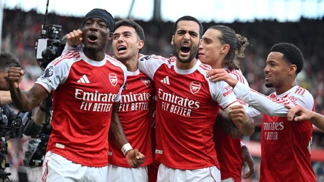 Arsenal players moving into attacking positions during a match